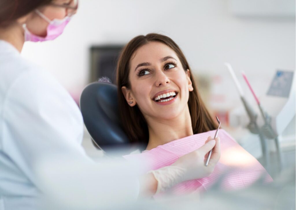 Patient discussing treatment with a dentist during a dental exam after discovering signs that may indicate a cavity.