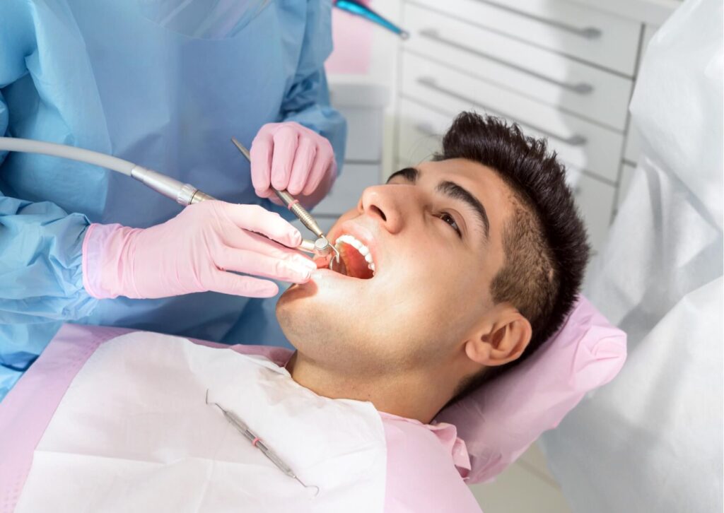 Dentist examining a patient’s teeth during an evaluation for a loose adult tooth to identify underlying causes and treatment options.