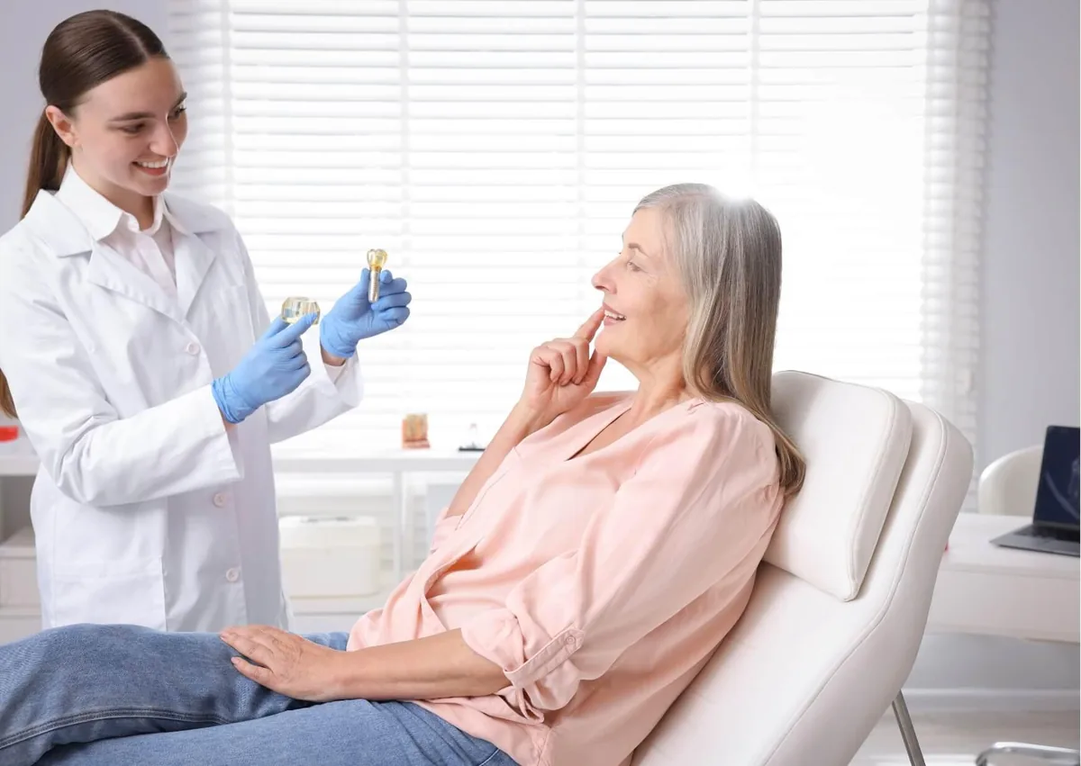 Dentist explaining the tooth implant process and how long treatment may take to a patient.