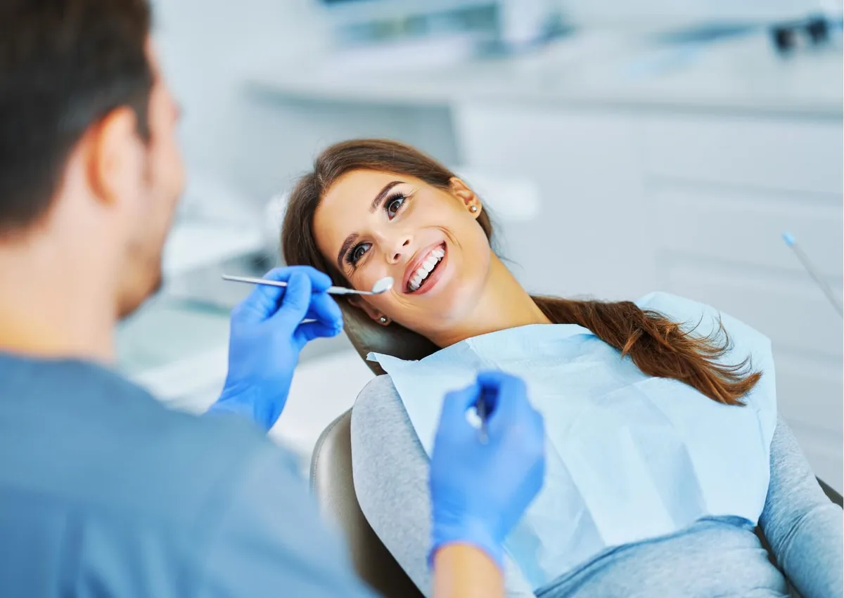 Patient smiling during a dental consultation to discuss treatment options for a smile makeover.