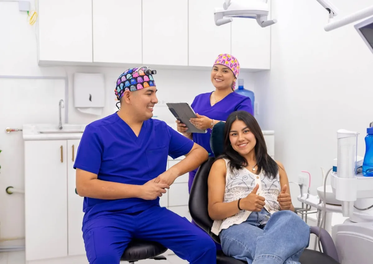Dental team with a patient during a visit to discuss dental sealants for cavity prevention.