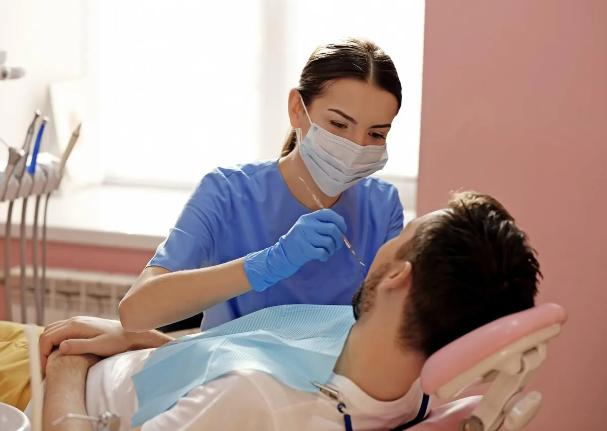 Dentist examining a patient’s teeth for visible signs of cavities and tooth decay.